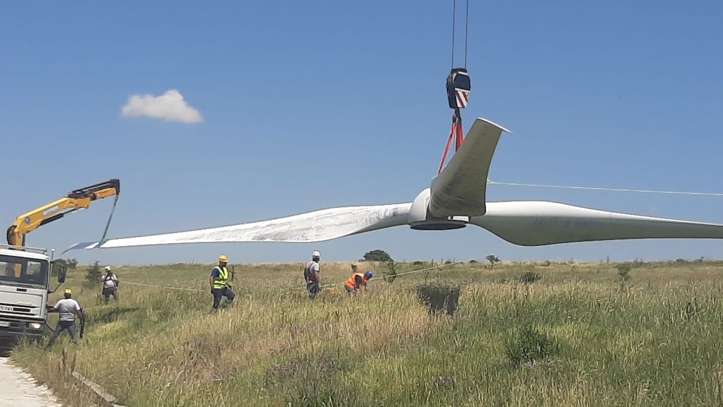Sollevamento pala in campo con tecnici a terra